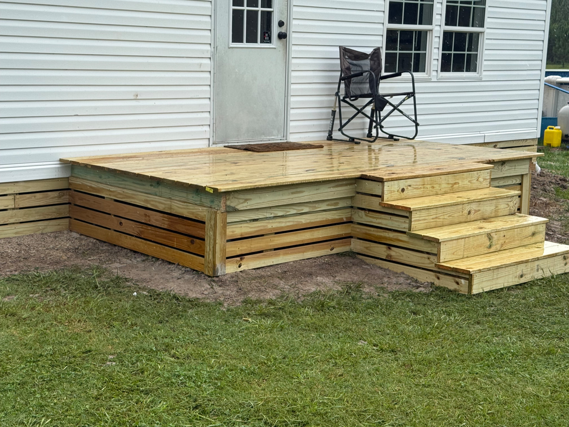 Newly built pressure-treated deck landing and stairs at a back door